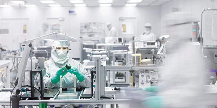 Assembly worker fabricating semiconductors and components in a Swagelok cleanroom