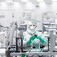 Assembly worker fabricating semiconductors and components in a Swagelok cleanroom