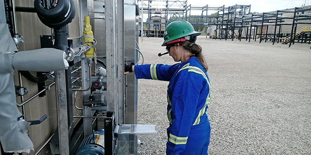 Stacey Phillips, la directora de ingeniería de campo de Swagelok para el continente americano, utiliza unos cascos de realidad aumentada para hacer una evaluación del equipo analítico de una instalación de procesamiento de gas natural con un equipo virtual. 