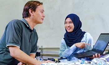 Two engineers reviewing a package‑level fluid system layout 